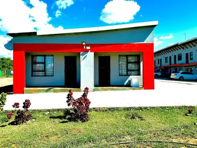 a small house with red paint on a street at Monavy Riverside Hotels in Tzaneen in Lenyenye