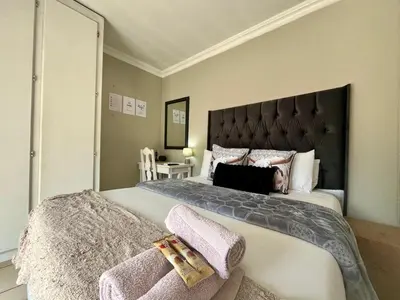 a bedroom with a large bed with a black headboard at OR Tambo Stay Unit 4 in Boksburg