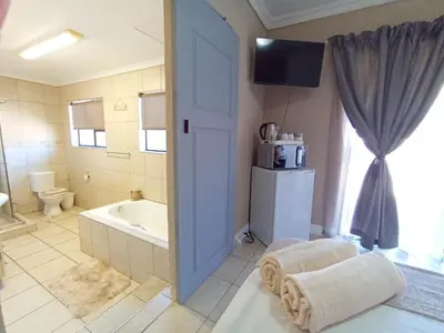 a bathroom with a tub and a toilet and a bath tub at OR Tambo Stay Unit 4 in Boksburg