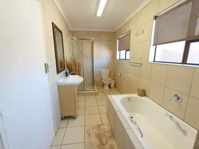 a bathroom with a tub and a sink and a toilet at OR Tambo Stay Unit 4 in Boksburg