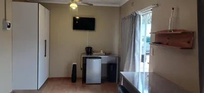 a living room with a refrigerator and a window at Risima guest house in Kempton Park