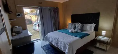 a bedroom with a bed with a blue blanket at Risima guest house in Kempton Park