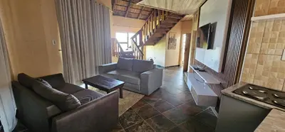 a living room with two chairs and a couch and a television at Elias Nefale Eco Estate in Mitxetweni