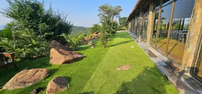 a garden with rocks in the grass next to a building at Elias Nefale Eco Estate in Mitxetweni