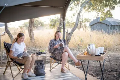 two women sitting in chairs under a tent at Kruger Untamed - Satara Plains Camp in Die Brug