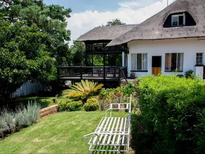 a white bench in the yard of a house at Boven Villa in Waterval Boven