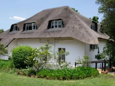 a thatch roofed house with a thatched roof at Boven Villa in Waterval Boven