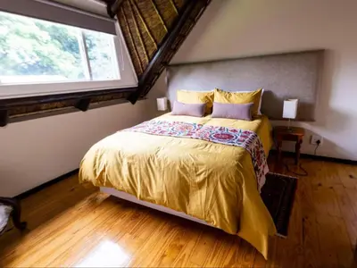 a bedroom with a bed with a large window at Boven Villa in Waterval Boven
