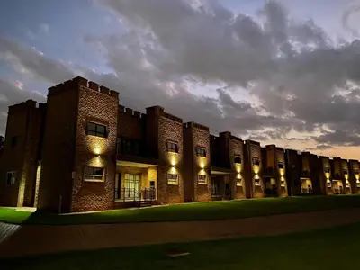 a large brick building with lights on it at Castle Walk Estate in Roodeplaat