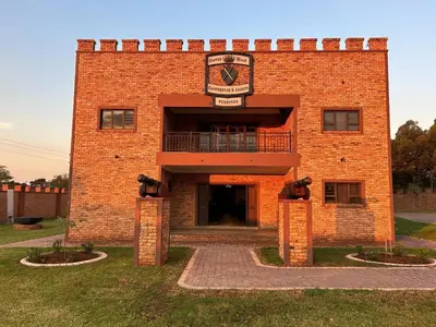 a red brick building with a sign on it at Castle Walk Estate in Roodeplaat