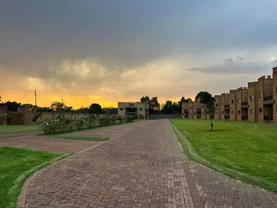 an empty brick road in front of a building at Castle Walk Estate in Roodeplaat