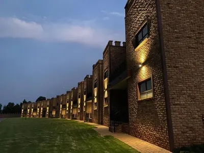 a row of brick buildings with lights on them at Castle Walk Estate in Roodeplaat