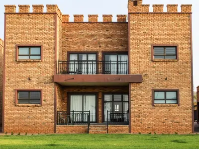 a brick building with windows and a balcony at Castle Walk Estate in Roodeplaat
