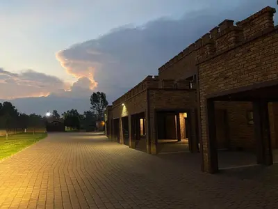 a brick building with a sunset in the background at Castle Walk Estate in Roodeplaat