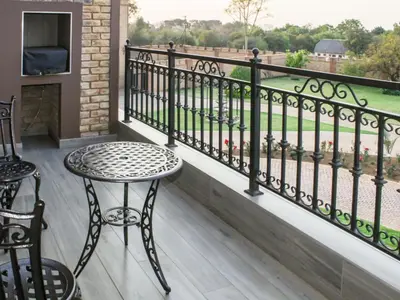 a balcony with a table and chairs and a view at Castle Walk Estate in Roodeplaat