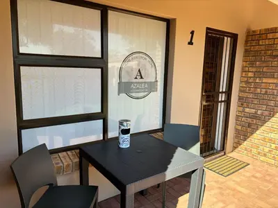 a table with a drink on it in a room with windows at Azalea Accommodation in Northam