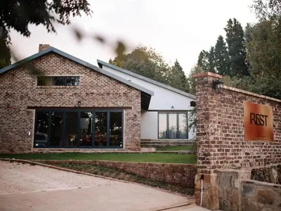 a brick building with a restaurant sign in front of it at Rest Guesthouse in Dullstroom