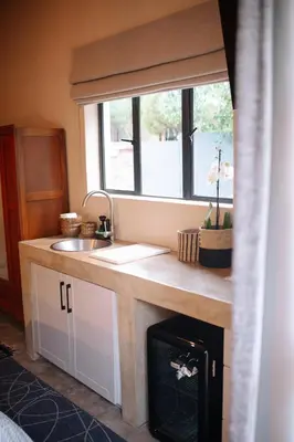 a kitchen with a sink and a counter with a fireplace at Rest Guesthouse in Dullstroom
