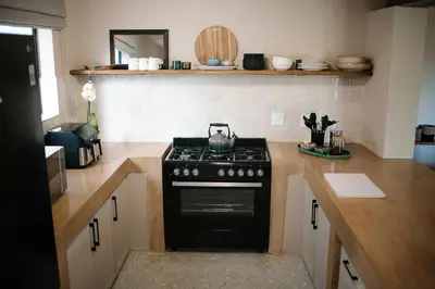 a kitchen with a stove with a tea kettle on it at Rest Guesthouse in Dullstroom