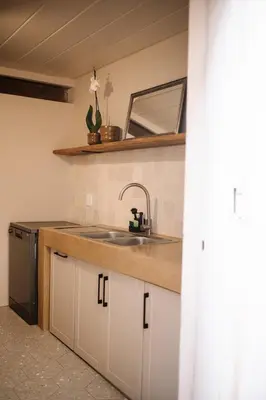 a kitchen counter with a sink and a mirror at Rest Guesthouse in Dullstroom