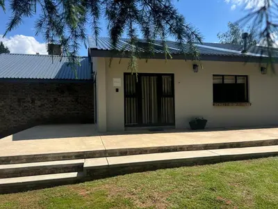 a house with a door and stairs in front of it at Rest Guesthouse in Dullstroom