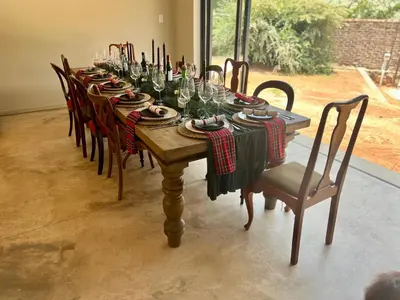 a long wooden table with wine glasses on it at Rest Guesthouse in Dullstroom