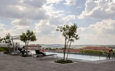 a view from the roof of a building with benches and trees at Cosy Ellipse 2012 Waterfall Midrand in Midrand
