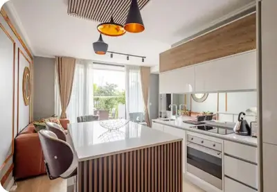 a kitchen with a white counter and a living room at Cosy Ellipse 2012 Waterfall Midrand in Midrand