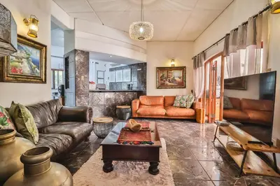 a living room with a couch and a table at Cascade Villa Guesthouse in Secunda