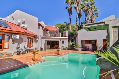 a swimming pool in the backyard of a house at Cascade Villa Guesthouse in Secunda
