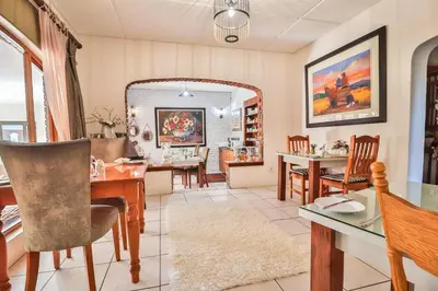 a dining room with a table and chairs at Cascade Villa Guesthouse in Secunda