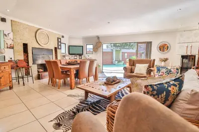 a living room with a couch and a table at Cascade Villa Guesthouse in Secunda