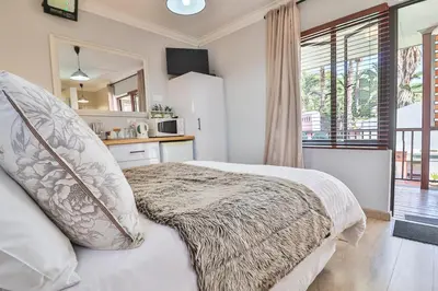 a bedroom with a bed with a blanket on it at Cascade Villa Guesthouse in Secunda