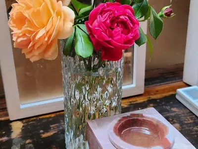 a vase with flowers in it sitting on a table at Bella Bohemia Spa, Venue and Guest Farm in Roodeplaat