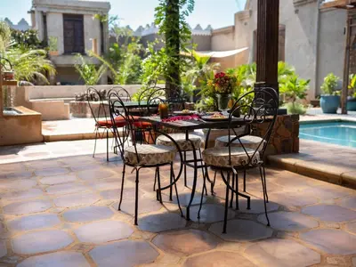 a table and chairs on a patio next to a pool at Bella Bohemia Spa, Venue and Guest Farm in Roodeplaat