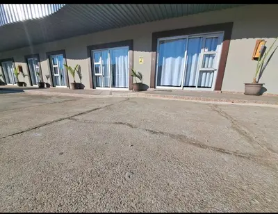 a row of windows on a building with potted plants at Nikita Portuguese Restaurant and Motel in Lanseria