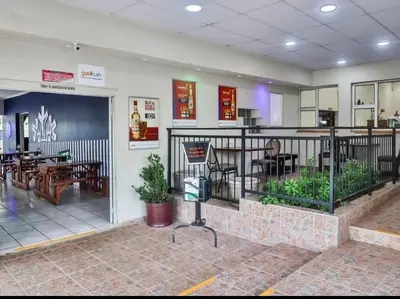 a lobby of a restaurant with tables and chairs at Nikita Portuguese Restaurant and Motel in Lanseria