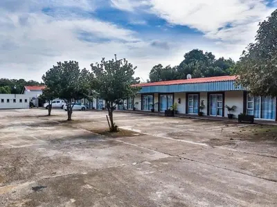 an empty parking lot in front of a building at Nikita Portuguese Restaurant and Motel in Lanseria