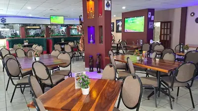 a dining room with wooden tables and chairs at Nikita Portuguese Restaurant and Motel in Lanseria