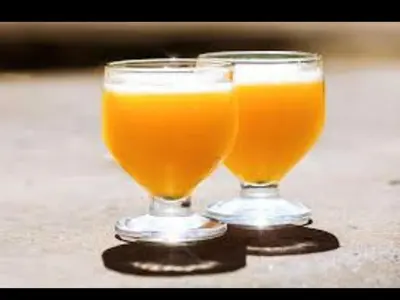 two glasses of orange juice sitting on a table at Nikita Portuguese Restaurant and Motel in Lanseria