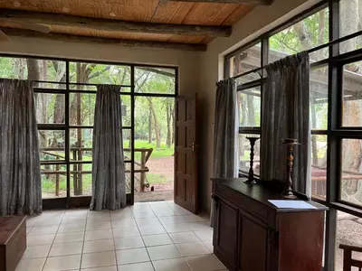 a living room with large windows and a door at Blyde River Studio Units - bottom unit in Hoedspruit