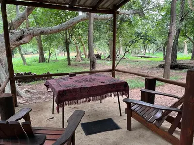 a table and chairs on a porch with a tree at Blyde River Studio Units - bottom unit in Hoedspruit
