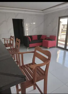 a living room with a red couch and chairs at Giyani Shamba Lodge in Giyani