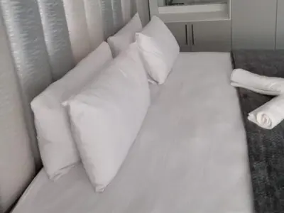 a white bed with pillows on it in a room at Giyani Shamba Lodge in Giyani