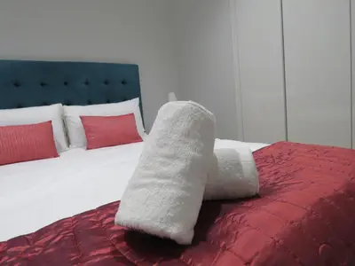 a white towel sitting on top of a bed at Entire Apartment in Waterfall, South Africa in Midrand