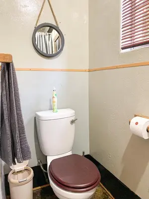 a bathroom with a white toilet with a brown seat at Havana Nights in Graskop
