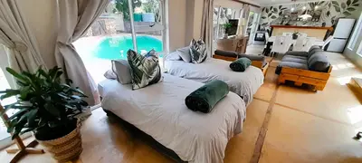 a living room with two couches and a swimming pool at Joy Haven - Open Plan Studio in Centurion