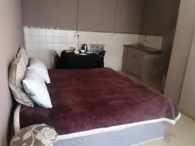 a bedroom with a large bed with white pillows at Walalawasala in Polokwane