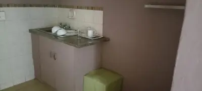 a bathroom with a sink and a green stool at Walalawasala in Polokwane