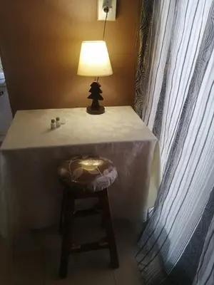 a table with a chair with a lamp on it at Walalawasala in Polokwane